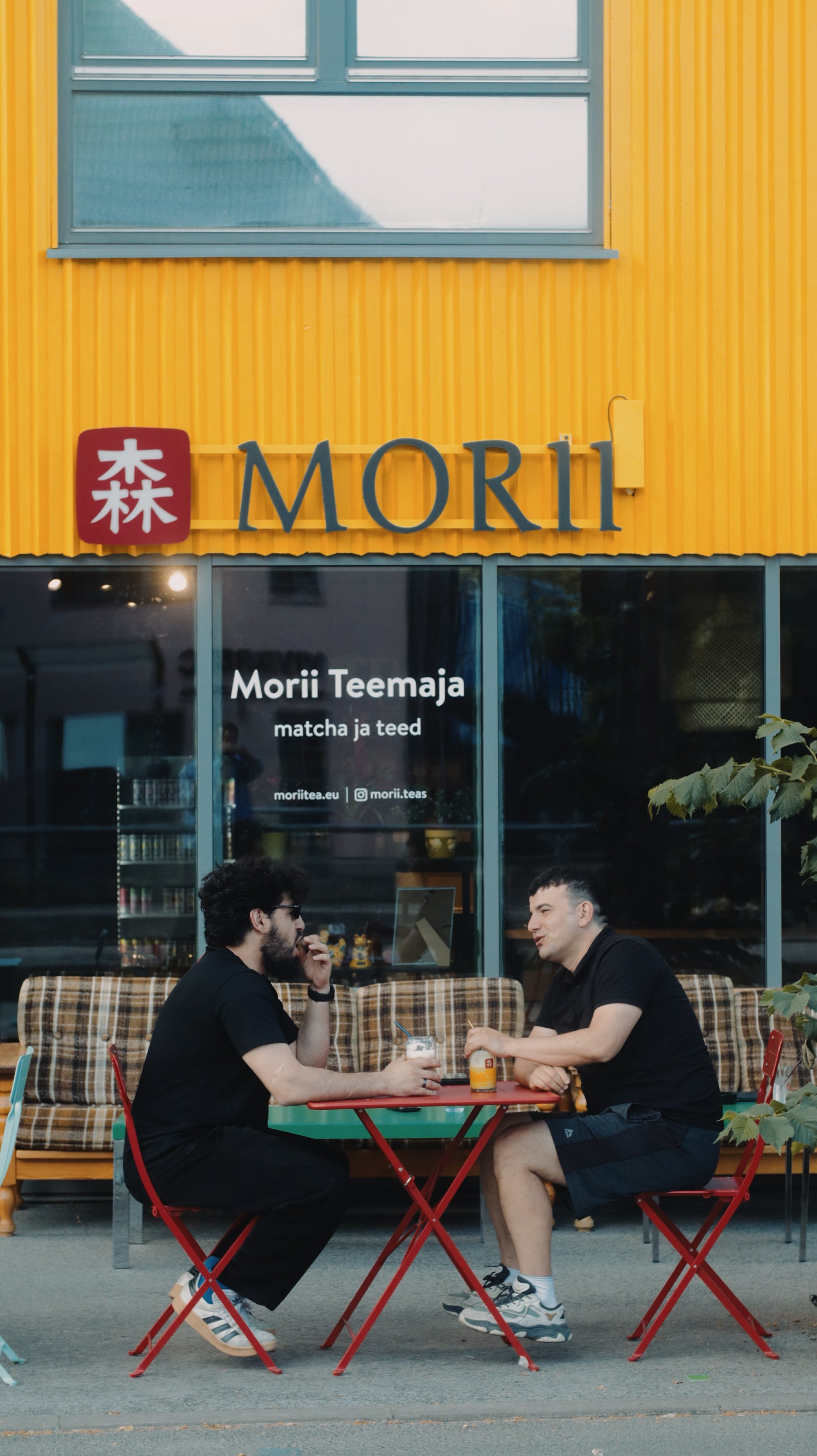 Morii Tea House at Kopli 16, Tallinn — guests at outdoor tables under the yellow facade